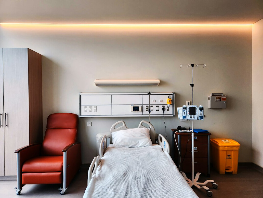 Clean modern hospital ward with an empty bed