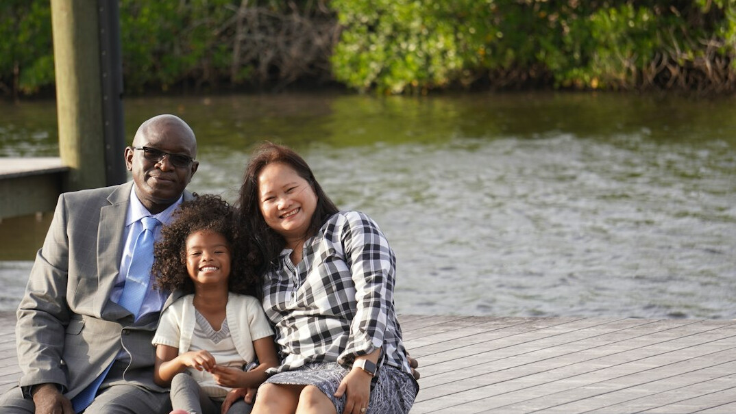 Chinese Singaporean insurance advisor smiling with a young family in a bright office